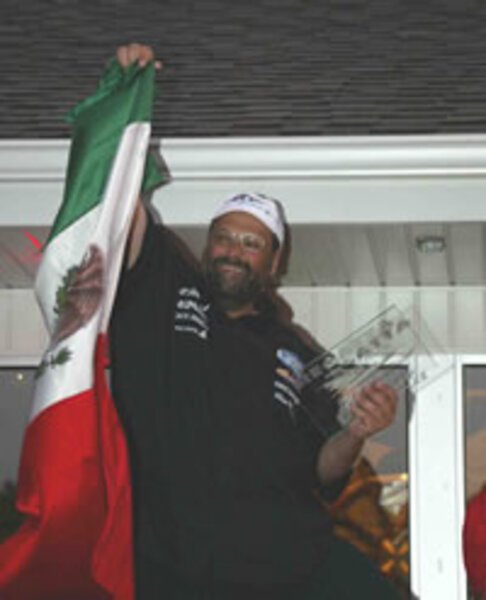 Carlos Kuri Slim celebrando en el podio con la bandera de México
